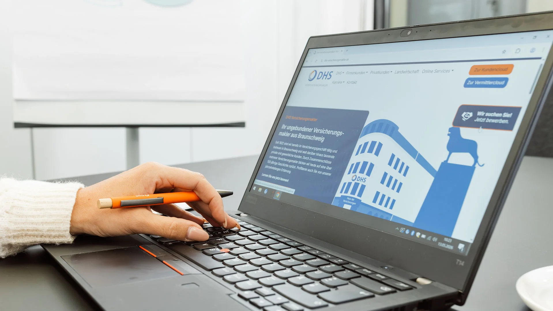 Laptop seitlich fotografiert mit Hand auf Tastatur