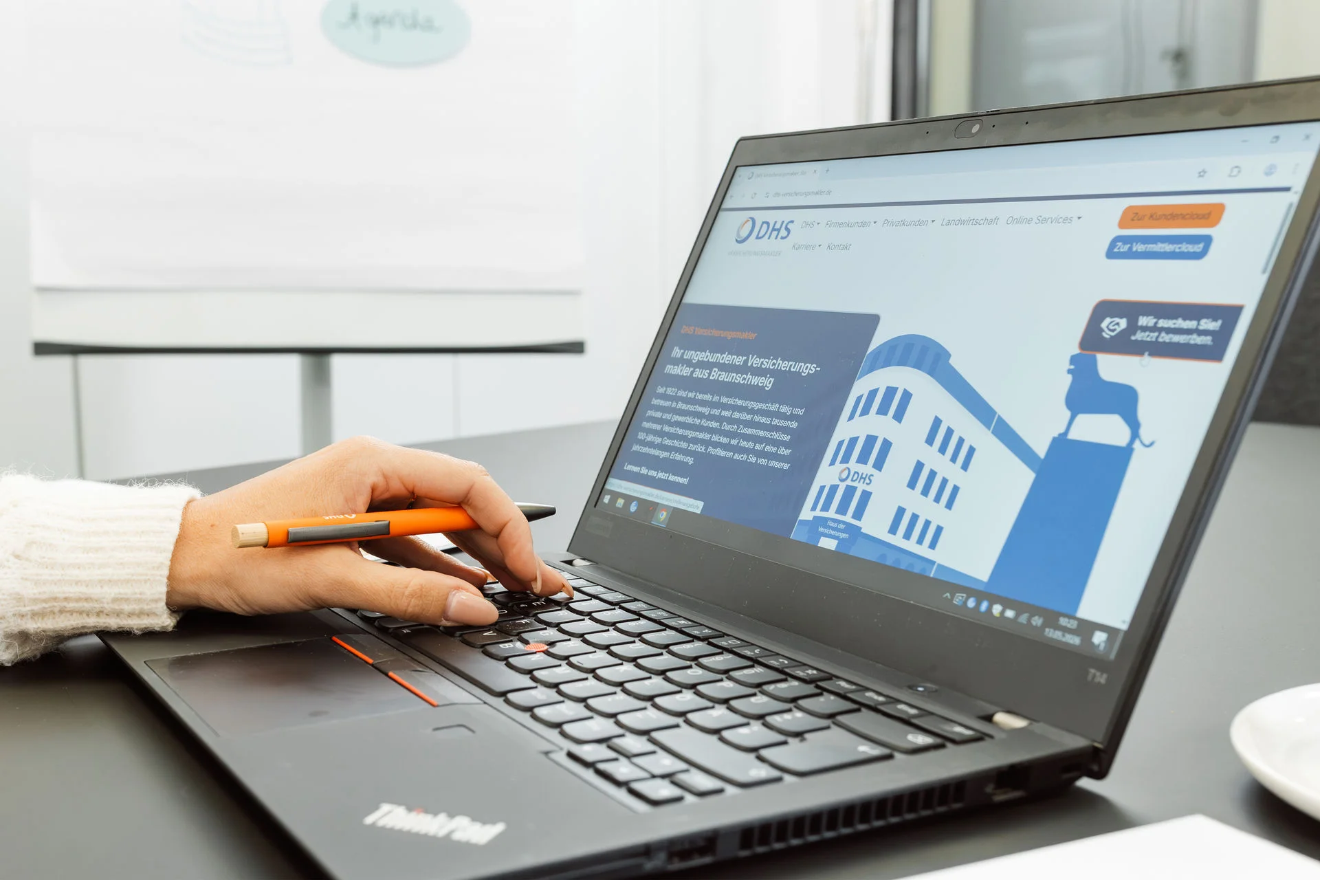 Laptop seitlich fotografiert mit Hand auf Tastatur