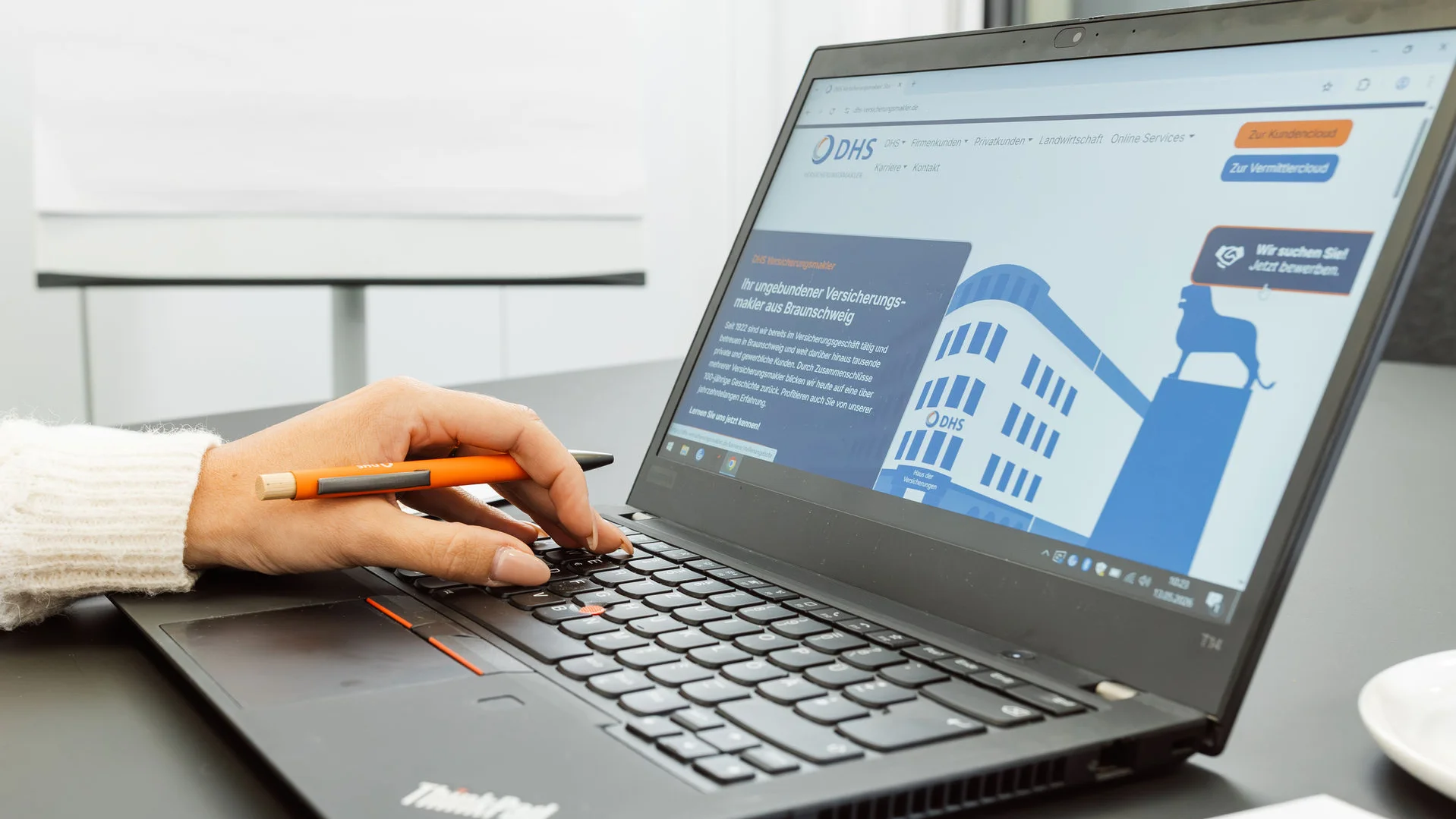 Laptop seitlich fotografiert mit Hand auf Tastatur
