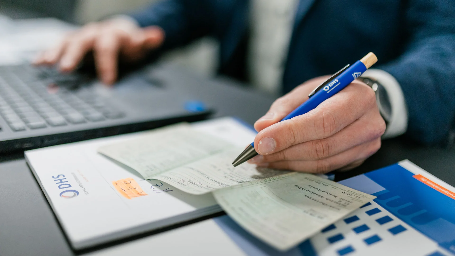 Hand hält blauen Stift und fährt über einen KFZ Schein